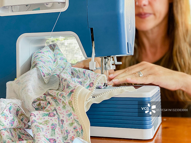 在露台上用缝纫机缝纫的女人图片素材