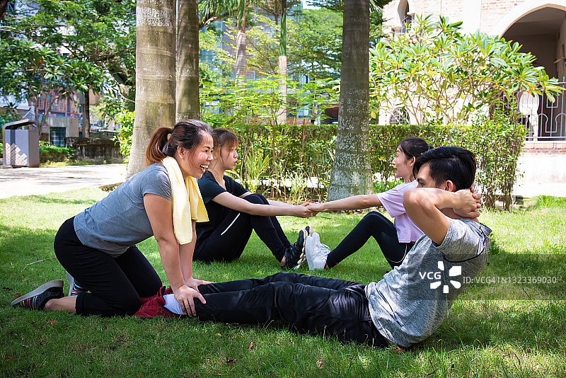 年轻运动员在户外做仰卧起坐图片素材