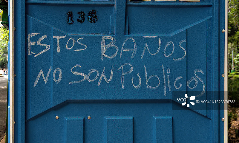 用粉笔写在移动厕所上的西班牙语信息：这些不是公共厕所图片素材