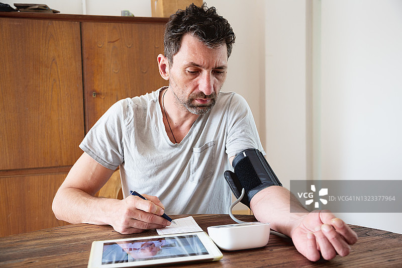 男人通过在线视频通话在家与医生交谈图片素材