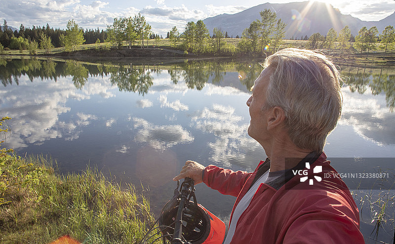 山地自行车手在阿尔卑斯湖附近休息图片素材