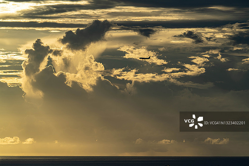 飞机飞越日本那霸市的日落海滩图片素材