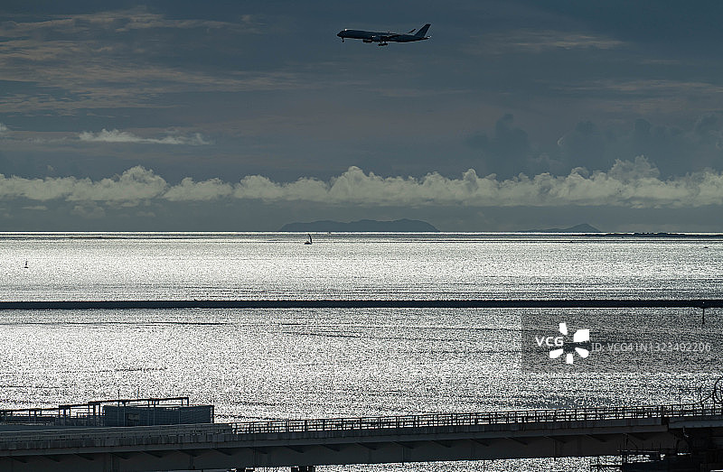 飞机在日本那霸市海滩上空飞行图片素材