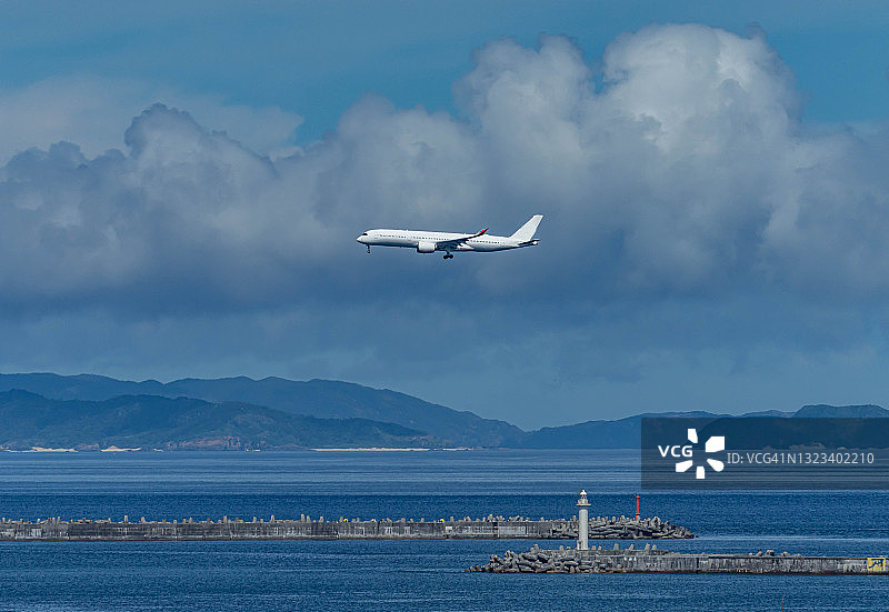 飞机在日本那霸市海滩上空飞行图片素材