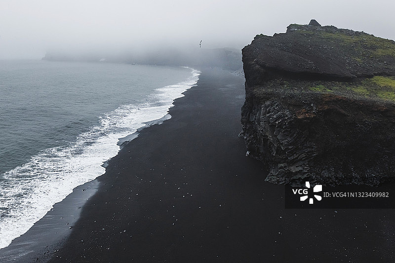 冰岛迪霍拉里海岸与黑沙滩，维克村，多云雾天气，下雨图片素材