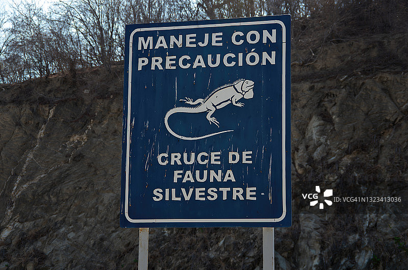公园里的西班牙语标志，上面写着“谨慎驾驶：野生动物十字路口”图片素材