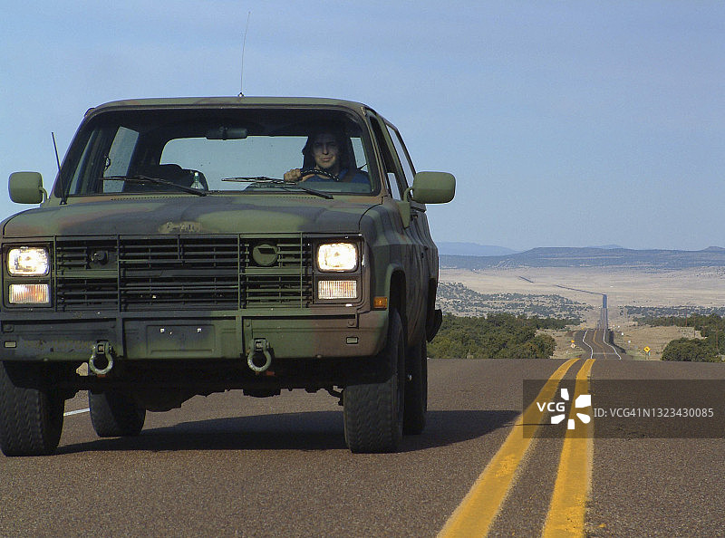 在美国高速公路上驾驶越野卡车的男人图片素材