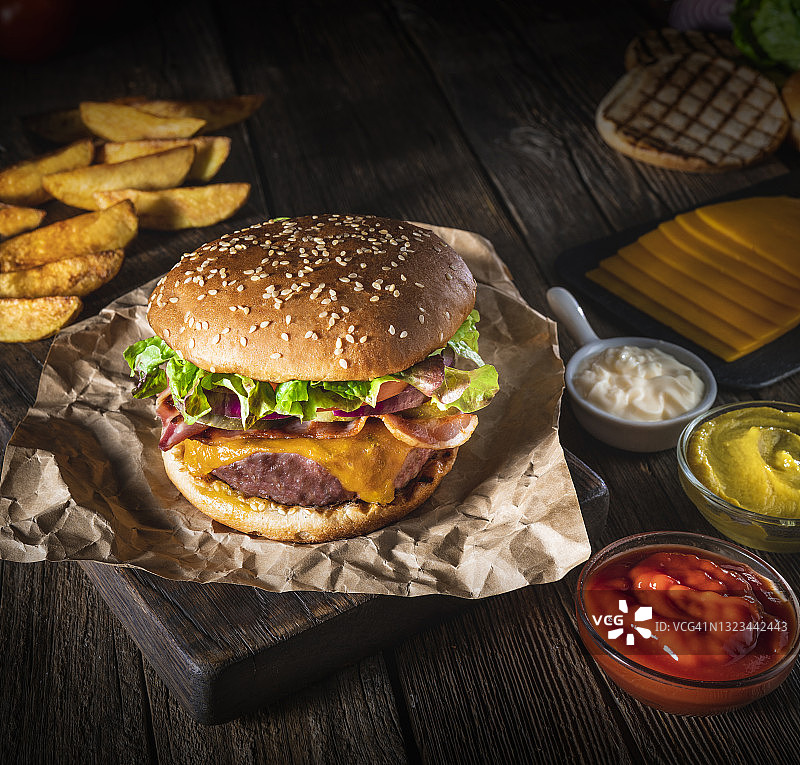 经典芝士汉堡肉饼与炸薯条套餐在乡村木桌上图片素材