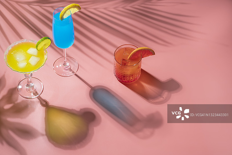 蓝色鸡尾酒，粉色背景下的玛格丽特和西柚无酒精鸡尾酒图片素材