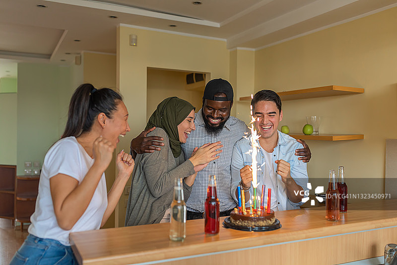 不同种族的快乐朋友们在家中一起庆祝生日派对图片素材