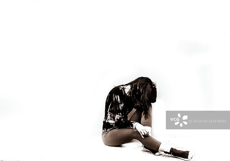 坐在白色地板上的悲伤成年女人，负面情绪图片素材