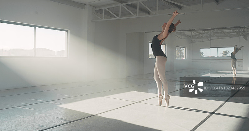 年轻女子在舞蹈工作室练习芭蕾舞全身照图片素材