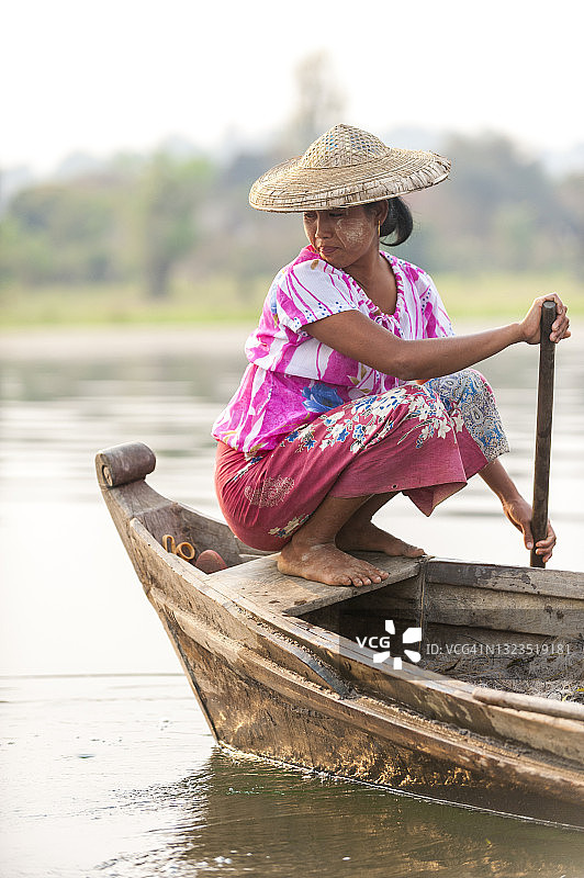 在缅甸茵达瓦吉湖，年轻女子在一天结束时收网图片素材