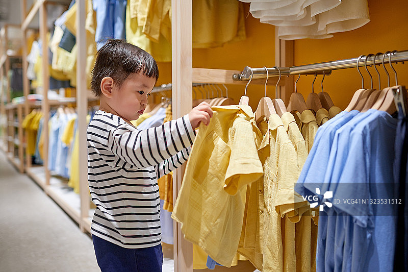 男孩在服装店挑选衣服图片素材