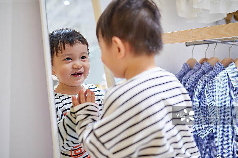 男孩在镜子前试穿衣服图片素材