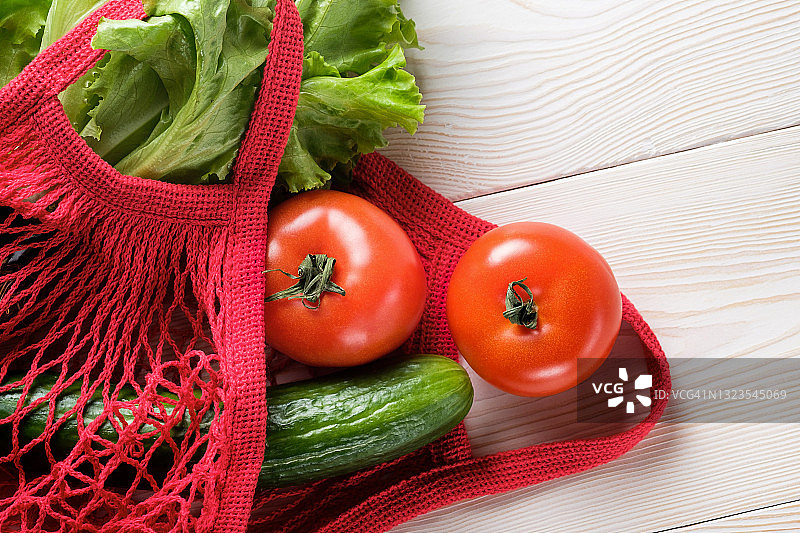 可重复使用购物袋中的新鲜多汁蔬菜和绿色沙拉，木质或厨房桌背景。素食主义，纯素食主义，生食。无塑料环保生活方式。图片素材