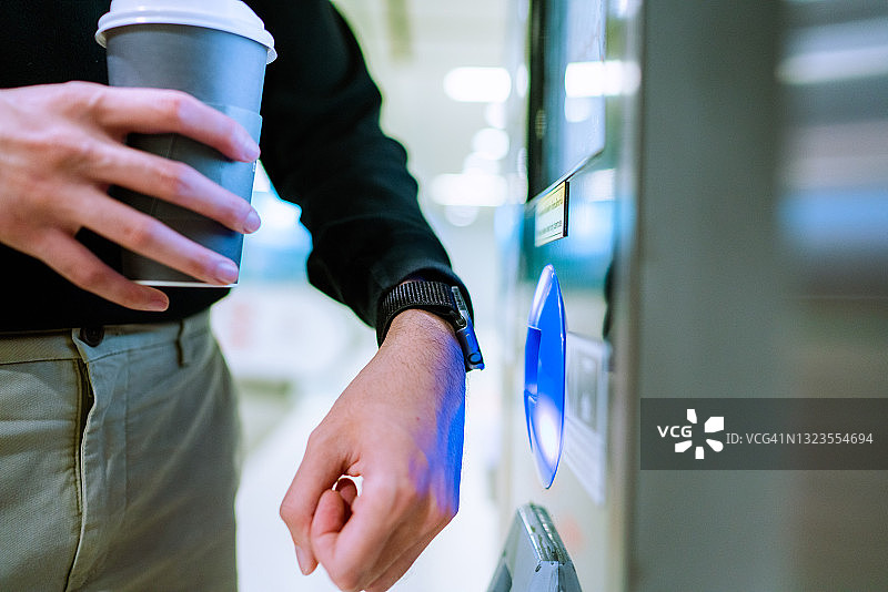 亚洲男人使用智能手表在BTS车站进行非接触式支付图片素材