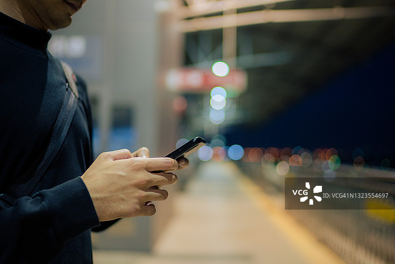 年轻的亚洲男子在地铁上使用智能手机图片素材