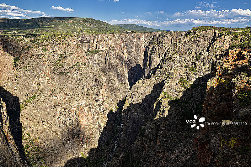 阳光下的峡谷、河流与山坡图片素材