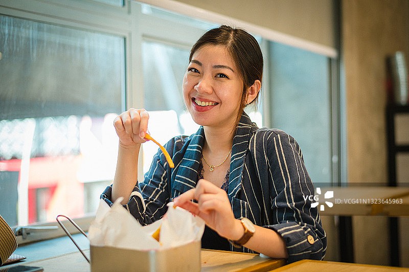 亚洲女商人在午休时间在联合办公室吃外卖图片素材