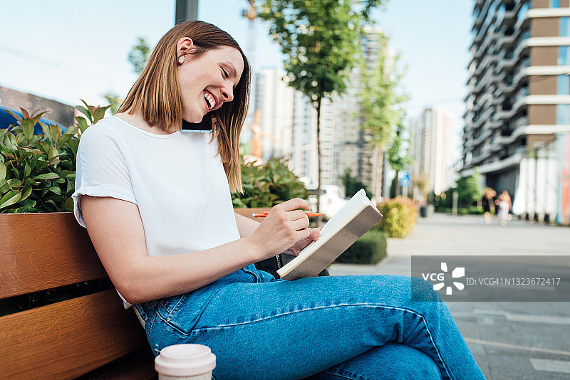 快乐的学生在街上打电话和学习图片素材