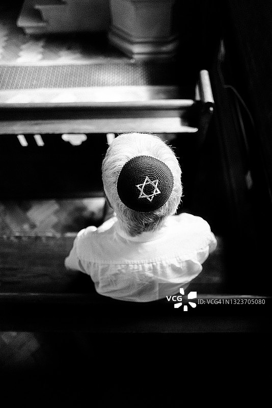 戴着小圆帽的年长犹太男子在犹太教堂内祈祷图片素材