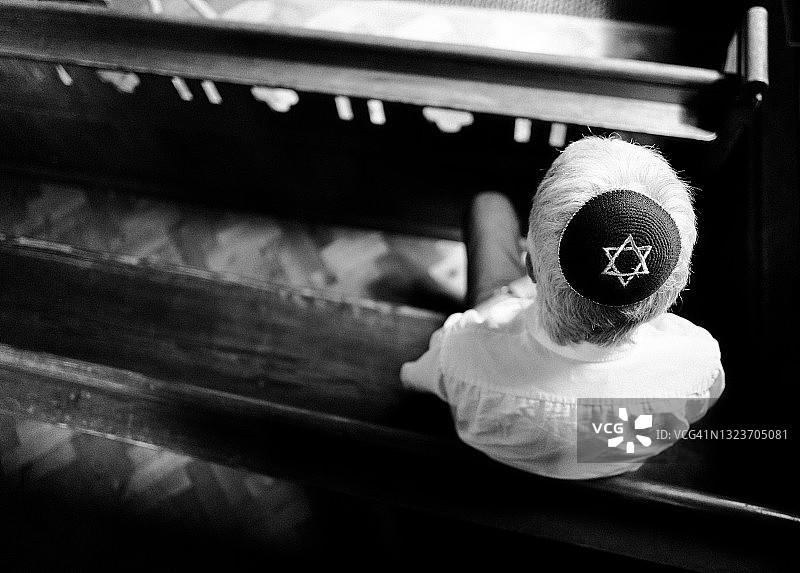 戴着小圆帽的年长犹太男子在犹太教堂内祈祷图片素材