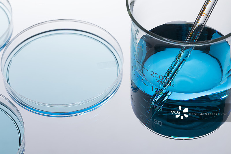 带有蓝色液体和移液器的培养皿图片素材