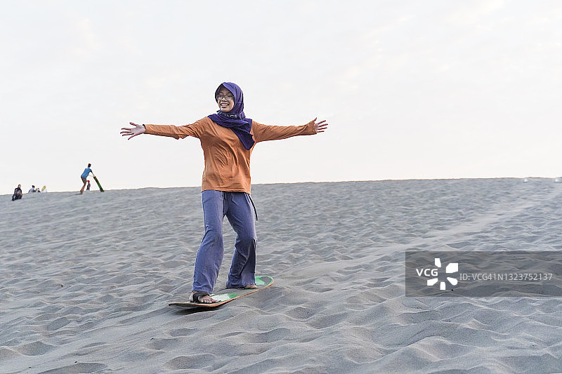 年轻女孩玩滑沙图片素材