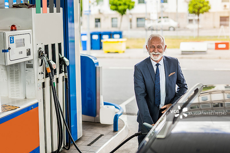 年长的男人在加油站给汽车加油图片素材