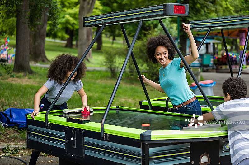 一位非裔美国母亲和她可爱的孩子们一起玩气垫球图片素材