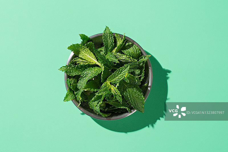 绿色背景上的一小盘薄荷糖图片素材