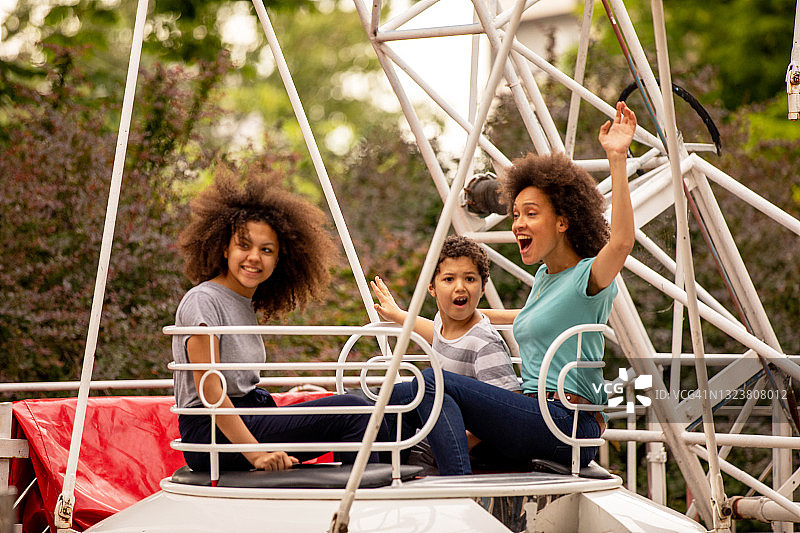 快乐的母亲和可爱的非裔美国孩子在游乐园玩耍图片素材