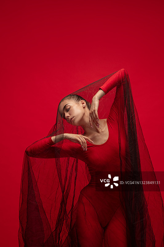 在红色背景中训练的年轻芭蕾舞女演员图片素材