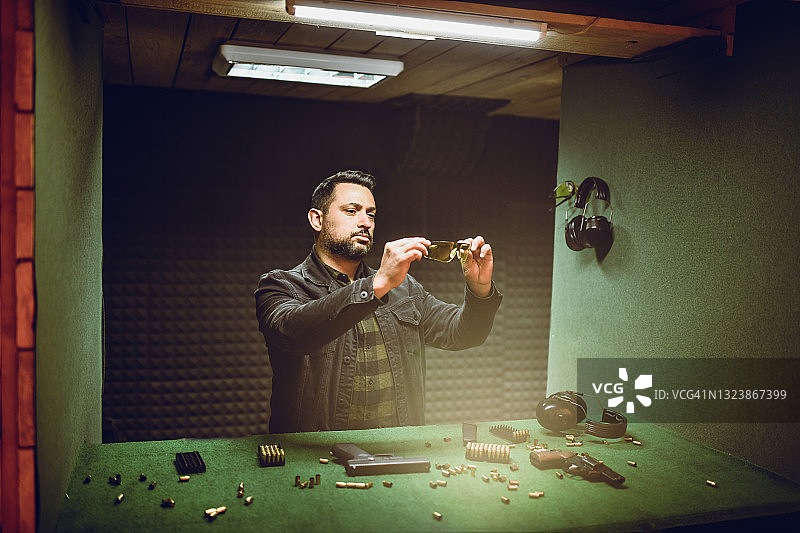 男子在射击练习前清洁眼镜图片素材