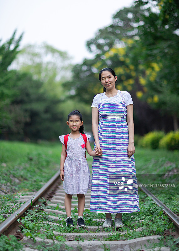 小女孩和母亲站在铁轨上图片素材
