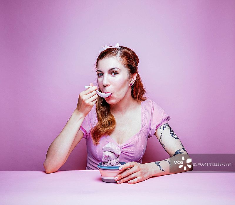 吃冰淇淋的可爱年轻女人，粉色主题图片素材