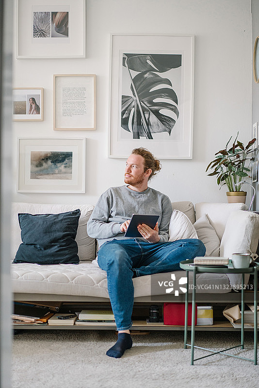 在客厅在线工作的年轻男人图片素材