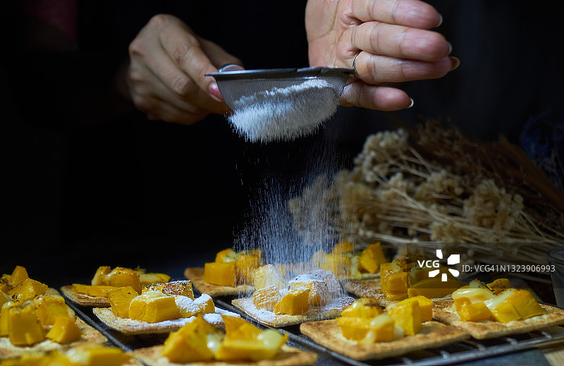 在饼干上撒糖霜和芒果沙拉图片素材