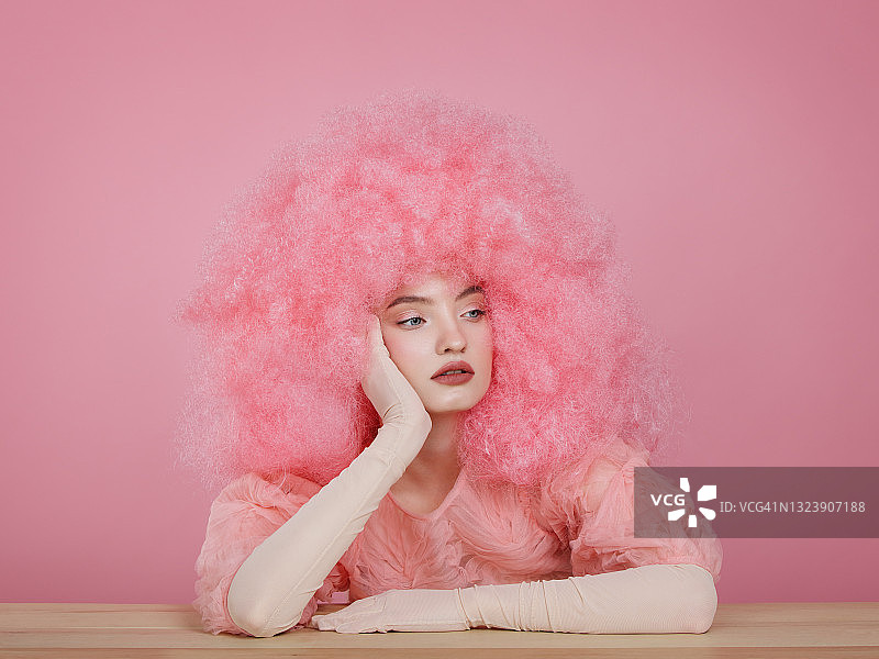 拥有粉色卷发的年轻美女图片素材