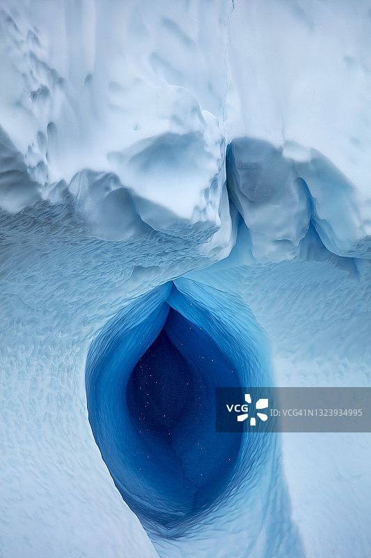 格陵兰伊卢利萨特迪斯科湾沿岸巨型冰山上的融水洞图片素材