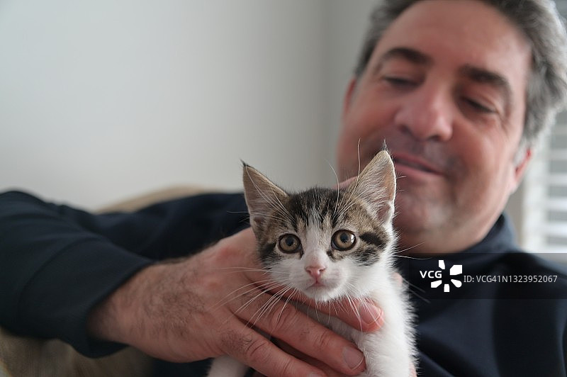中年男人享受可爱小猫的陪伴图片素材