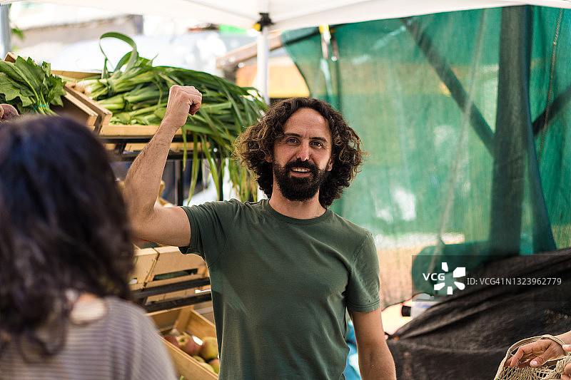 有机蔬菜市场摊贩向顾客售卖蔬菜图片素材