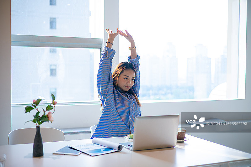 工作时伸展手臂放松的亚洲女性图片素材
