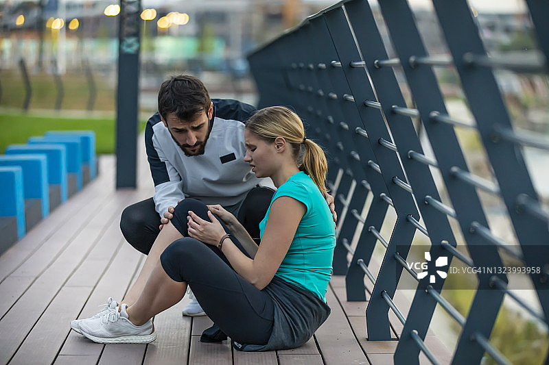 年轻女运动员在城市慢跑时膝盖受伤，她的队友也在图片素材