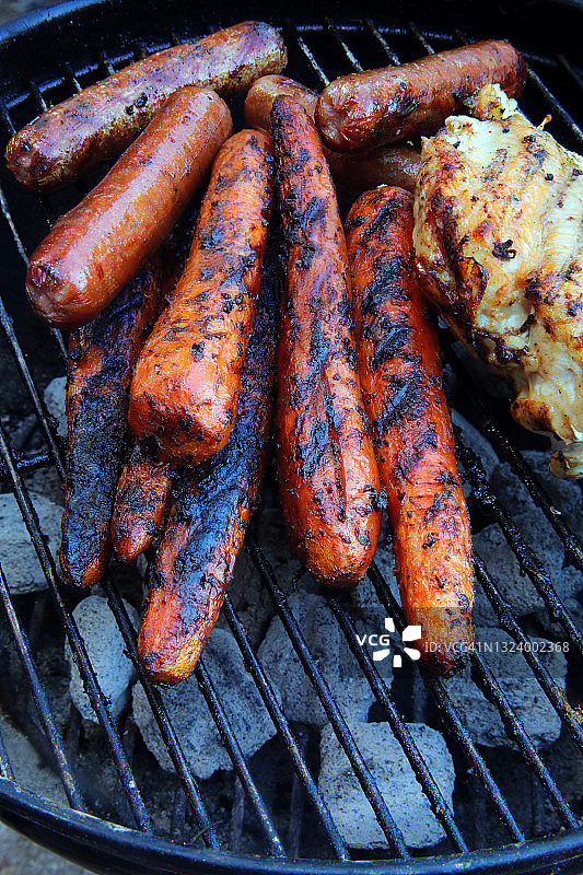 小烤架上的烤胡萝卜热狗和鸡肉图片素材