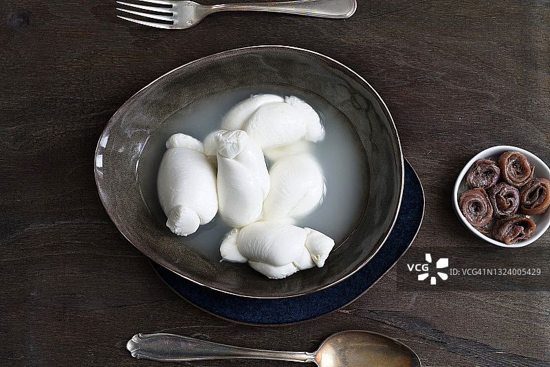 坎帕尼亚特色牛奶马苏里拉奶酪结、切塔拉凤尾鱼和橄榄油，深色木质背景，意大利，欧洲图片素材