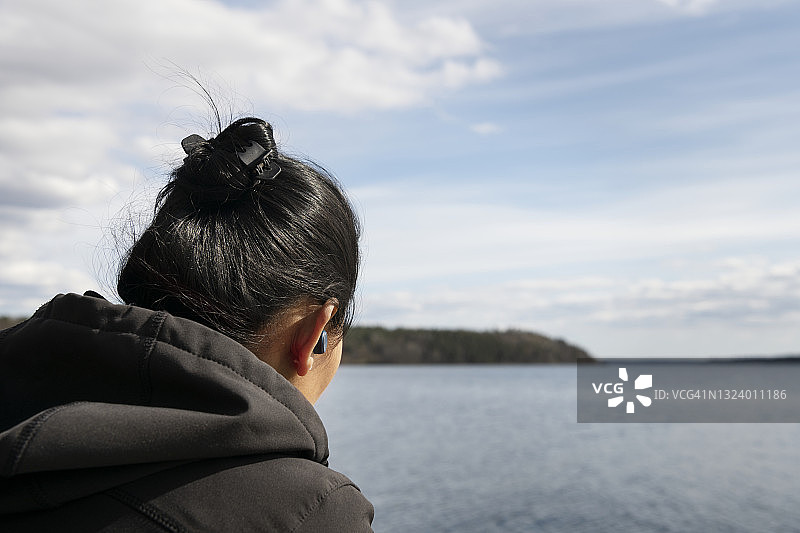 在湖边戴着耳机的女人图片素材