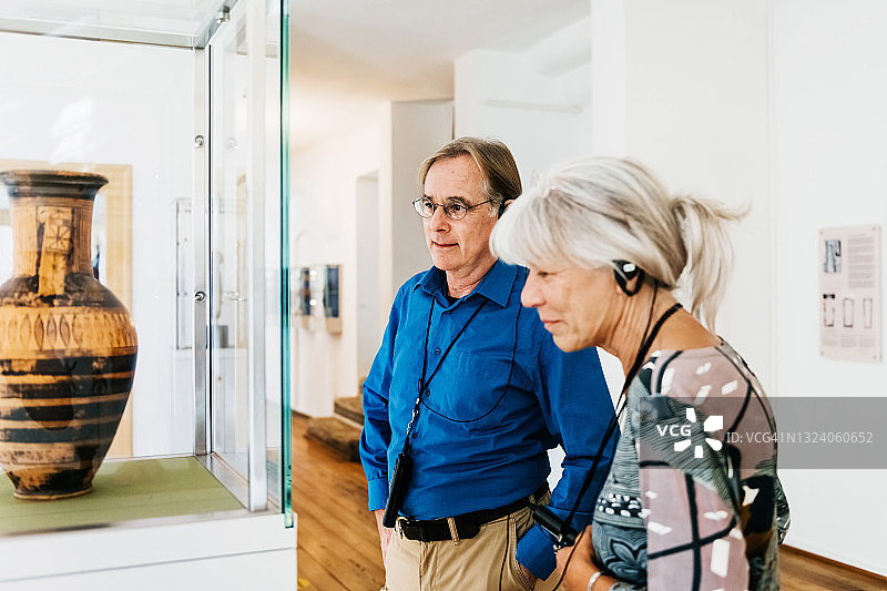 中年夫妇参观博物馆时听讲解图片素材
