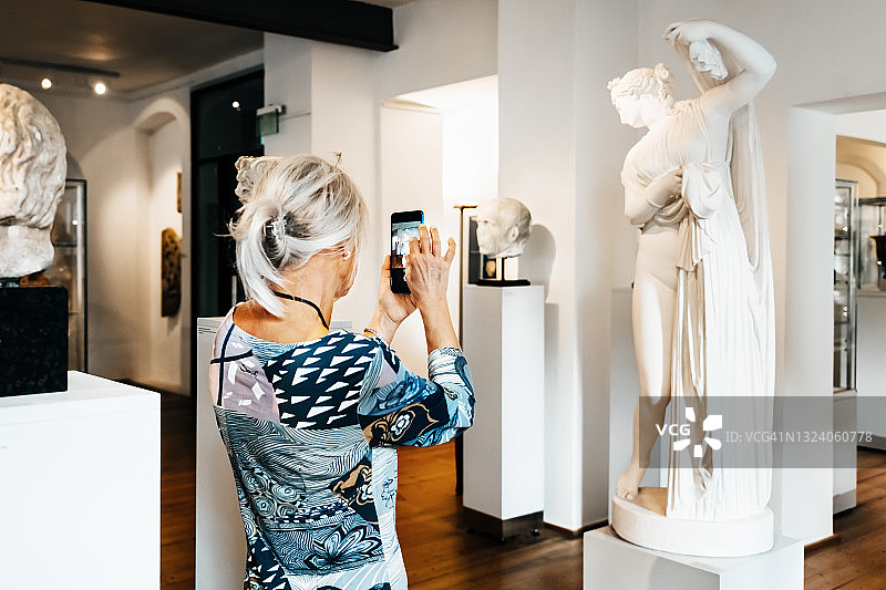 中年妇女拍摄古典雕塑图片素材